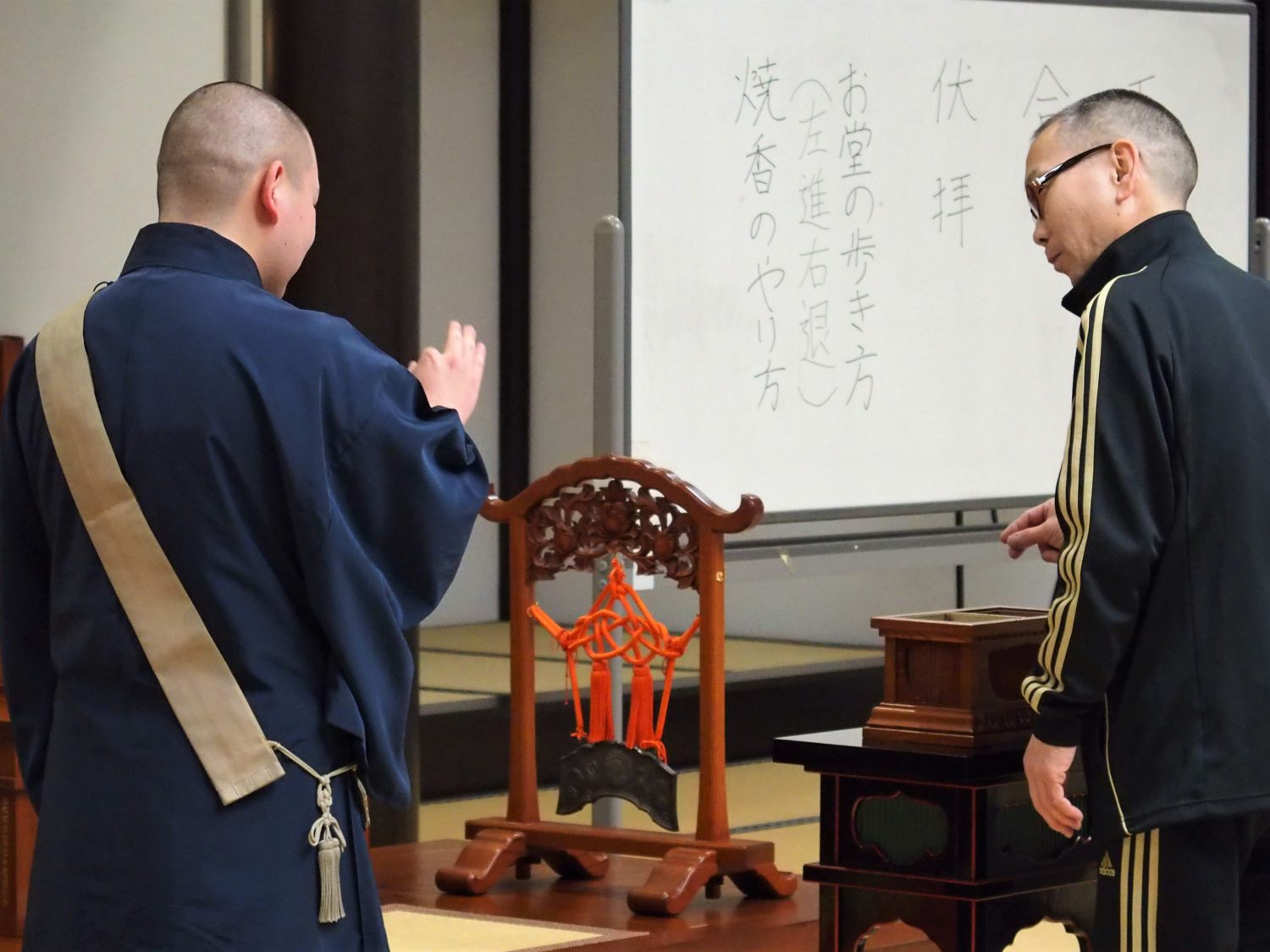 A Buddhist monk teaching how to "shoko (offer incense)"